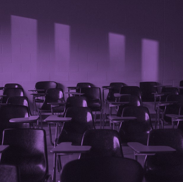 Aula vacía con pupitres iluminada por la luz de las ventanas